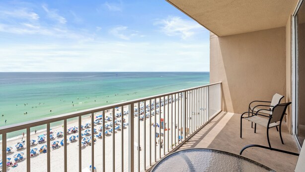 A balcony with a view of a beach and ocean.