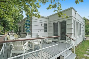 Een wit huis met een terras, buitenzitplaatsen en een overdekte patio.