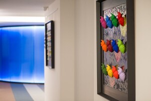 Un corridoio con un quadro che raffigura fiori di carta dai colori vivaci.