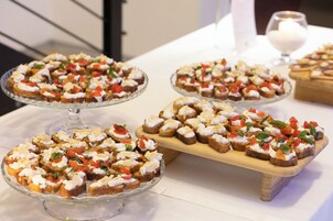 A table with various food items, including bread with toppings and a glass dish.