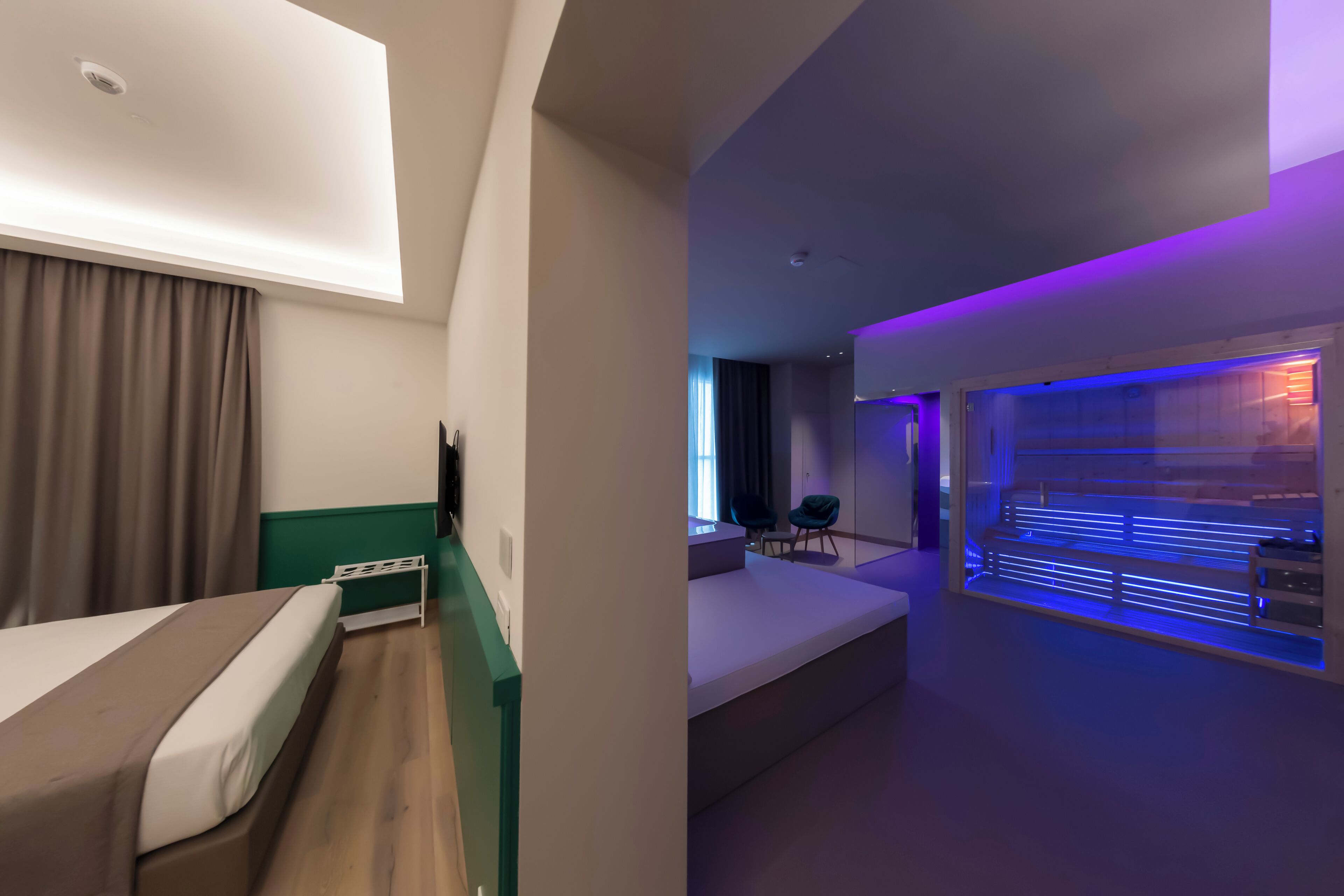 Una habitación de hotel moderna con una cama, un escritorio y una zona de estar con vistas a la ciudad.