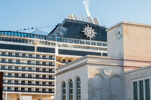 A cruise ship with multiple decks and a prominent logo on the upper deck.