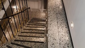 A staircase with a terrazzo floor and metal railings.