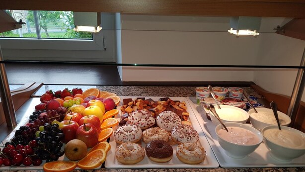 A buffet with fruits, pastries, and dairy products.