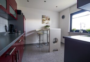 Apartamento empresarial, vista para o jardim | Cozinha privada | Micro-ondas, fogão, cooktop, lava-louças