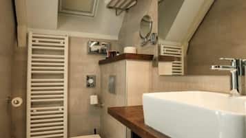A modern bathroom with a white sink, toilet, and towel rack.