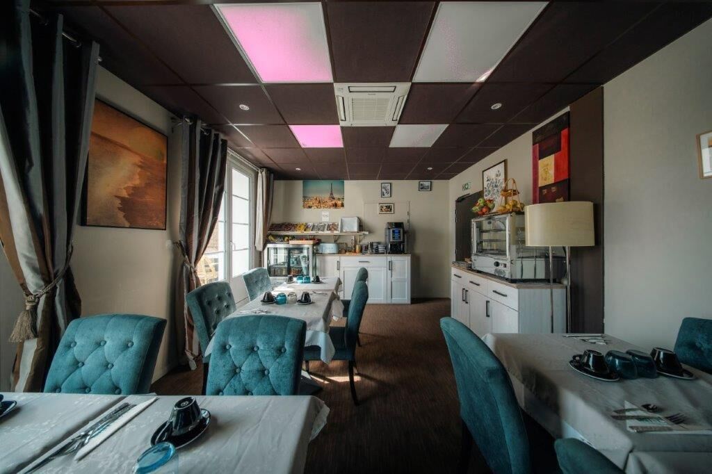 Ett hotellrum med en matplats, ett litet kök och ett stort fönster.