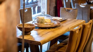 Ein Holztisch mit einer Glaskuppel, einer Schüssel und einem Teller mit Brot.
