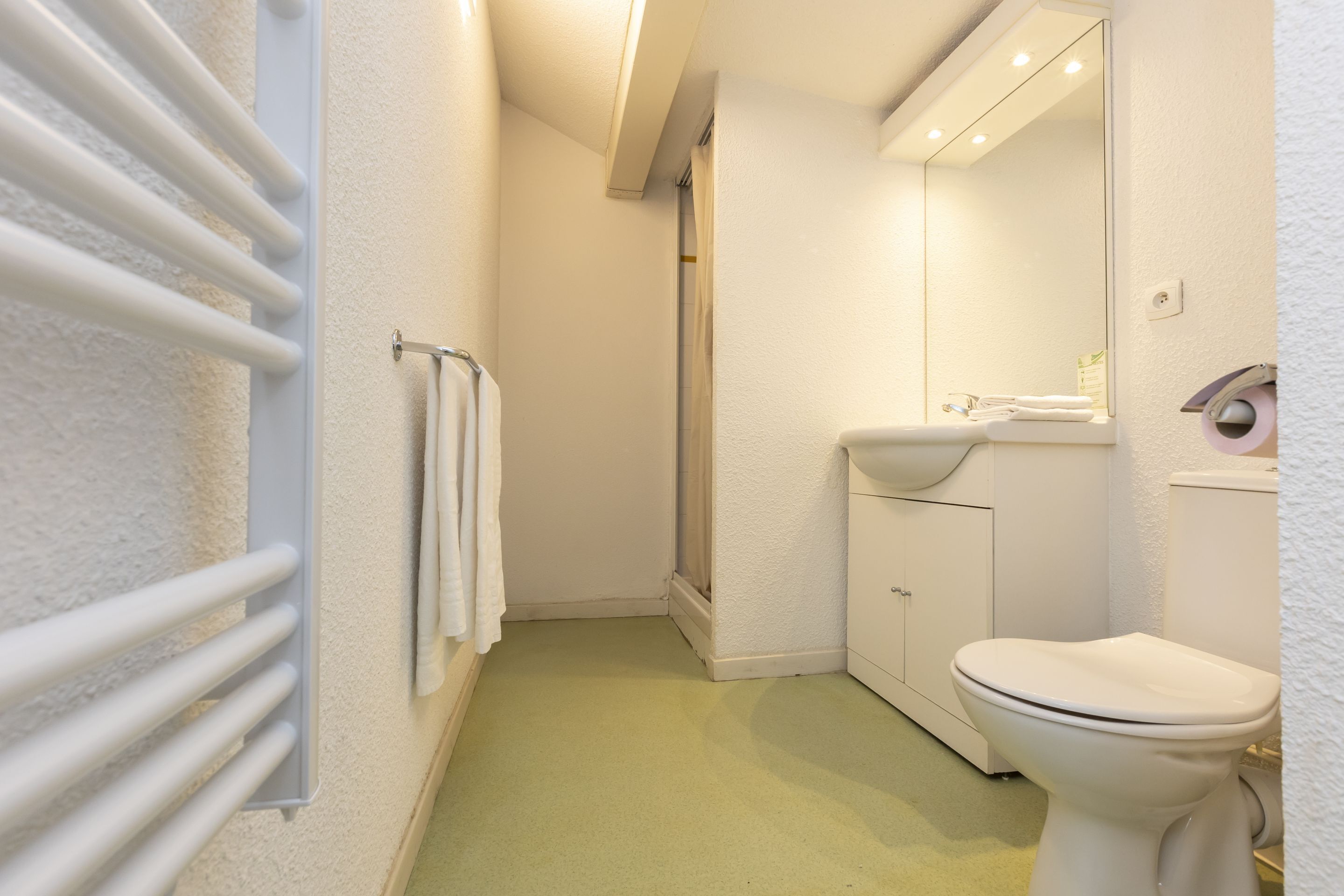 A bathroom with a toilet, sink, and shower.