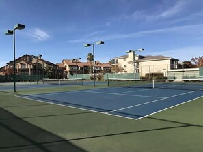 An outdoor tennis court with multiple courts, surrounded by residential buildings and street lamps. - Beautifully Remodeled Condo - Fountain Views (St. George)