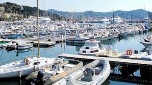 Un puerto deportivo con varias embarcaciones amarradas, incluyendo veleros y lanchas.