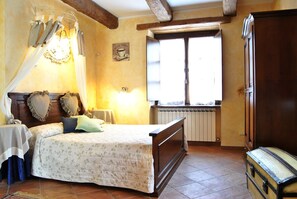 Une chambre à coucher avec un lit, une fenêtre, un radiateur et une porte en bois.