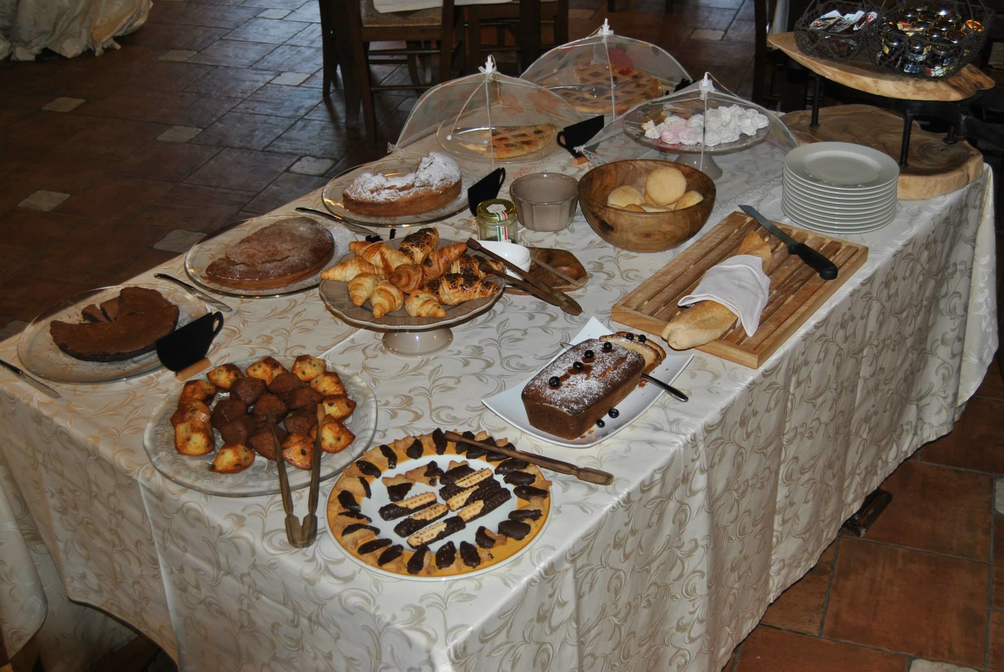 A buffet table with various desserts and pastries.