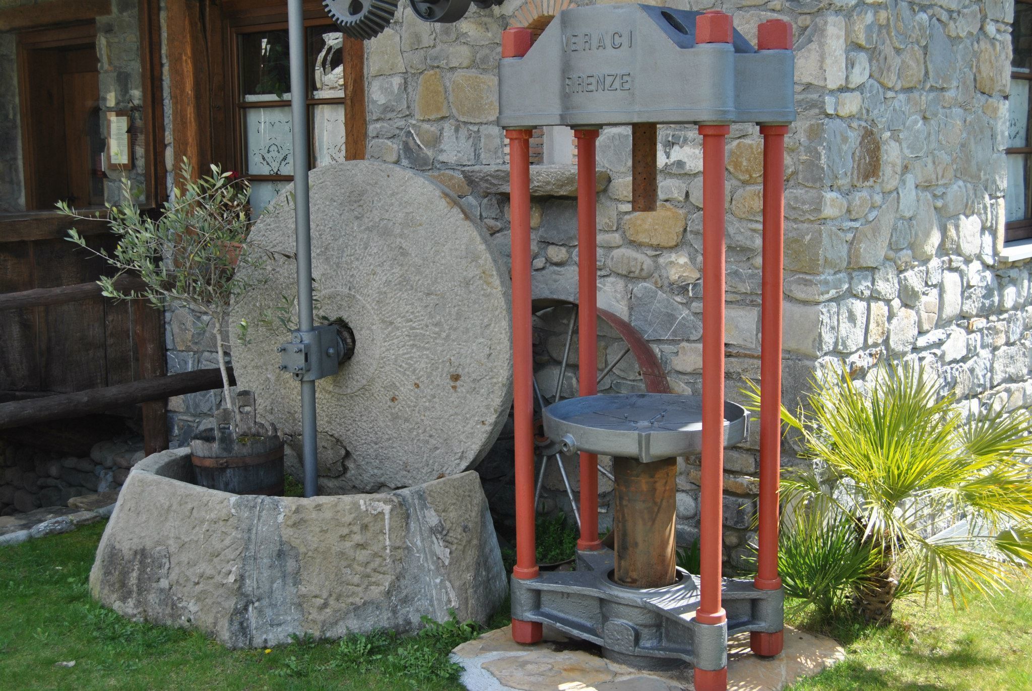A stone building with a water pump and a sign reading "TERACI RENZE".