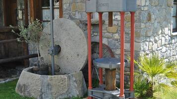 A stone building with a water pump and a sign reading "TERACI RENZE".