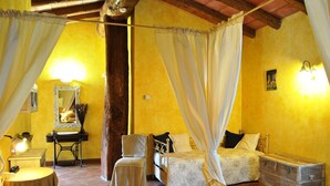 A bedroom with a bed, a chair, a nightstand, a mirror, and a dresser. - Le Macine del Confluente (Badalucco)