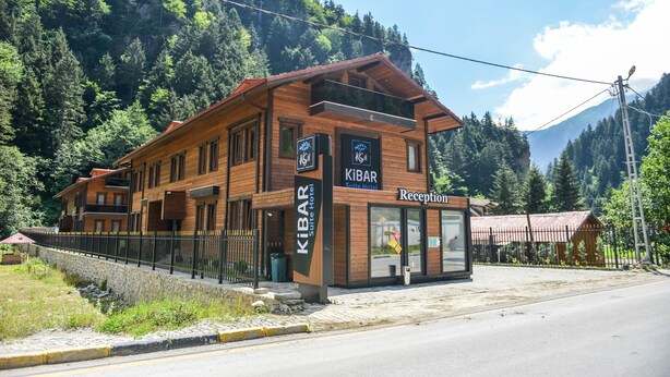 Un KIBAR Suite Hotel con una zona de recepción, situado cerca de un paisaje montañoso.