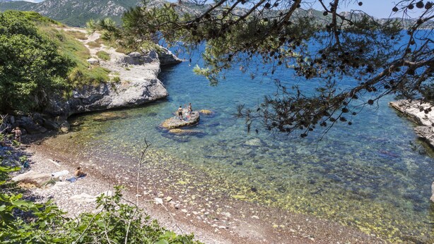 A clear coastal area with rocky shores and clear water, surrounded by greenery and mountains. - Résidence Odalys Casa d'Orinaju (Oletta)