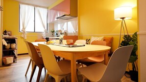 A dining area with a round table, chairs, and a lamp.