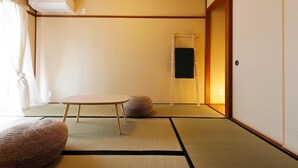 A traditional Japanese room with tatami flooring, a low table, and a shoji screen door.