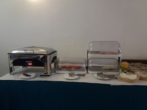 Montaje de bufé con horno tostador, mostrador de sándwiches y un expositor escalonado con alimentos.