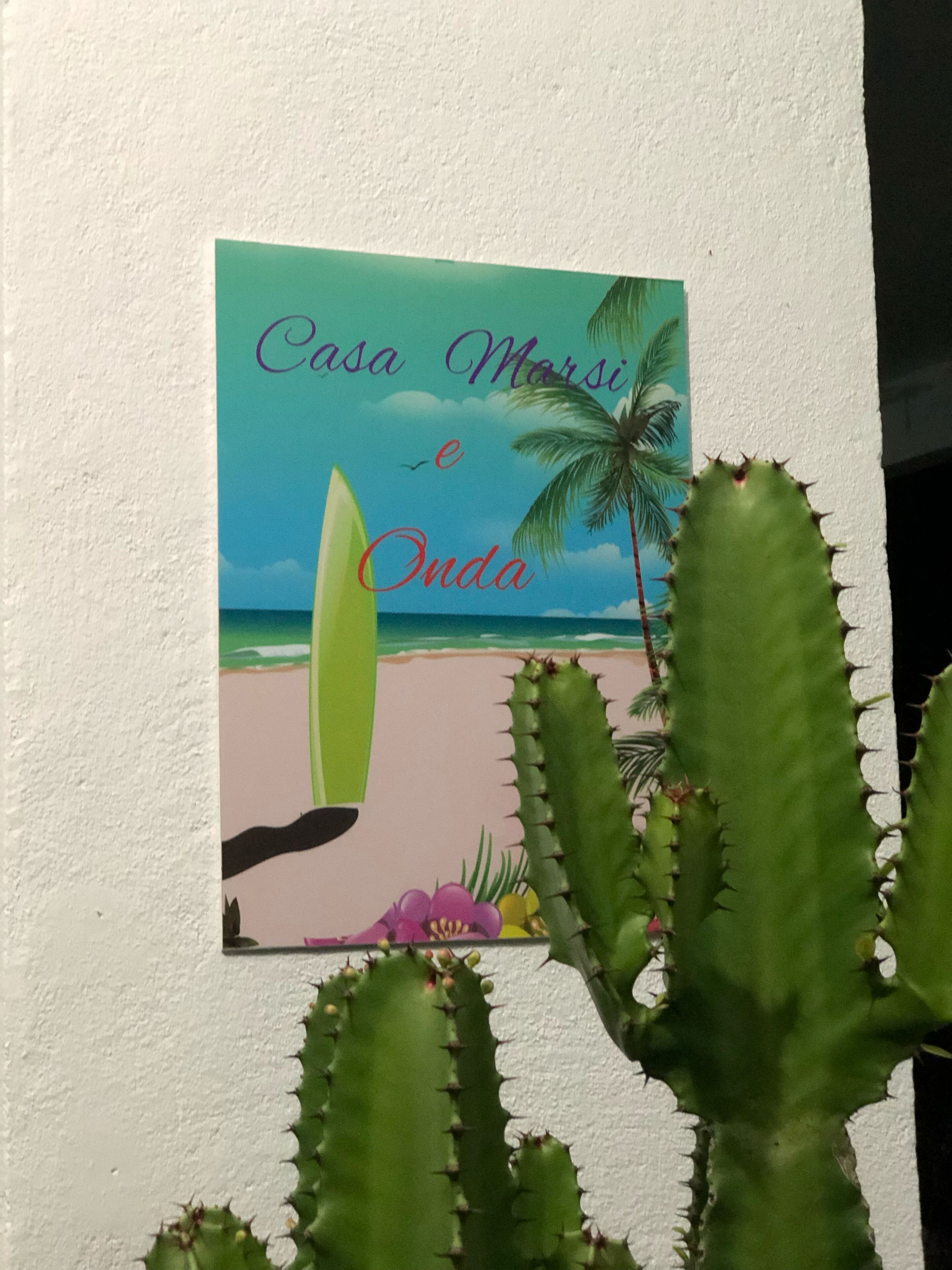 Un mur orné d’une affiche représentant une scène de plage et portant l’inscription « Casa Marsi e Onda ».