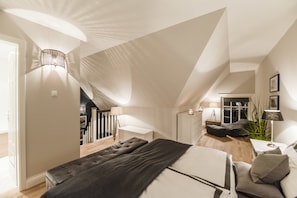 A bedroom with a large bed, a desk, and a window. - Kamphof Usedom Ferienanlage (Loddin)