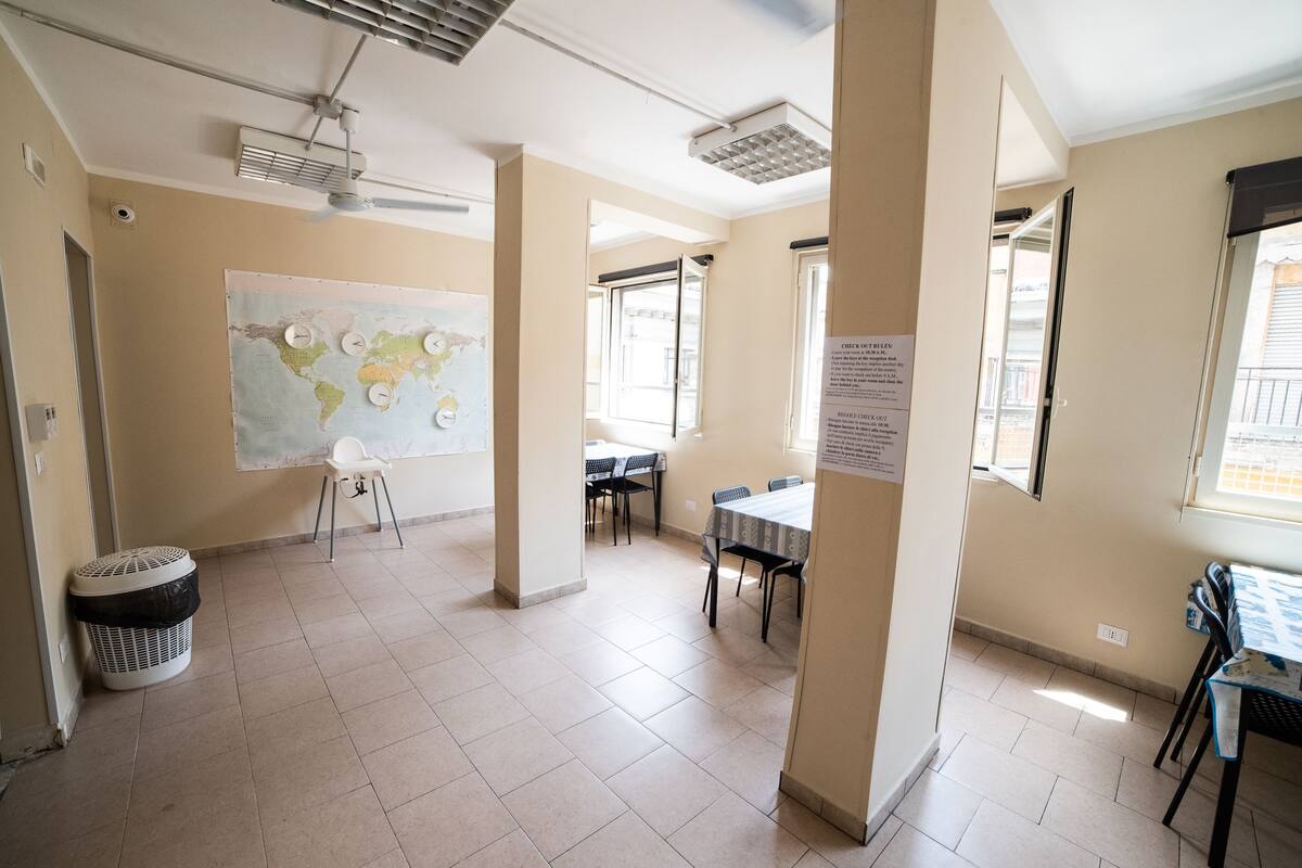 A spacious room with a large map on the wall, a dining table, and chairs.
