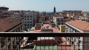 Un paysage urbain mêlant bâtiments résidentiels et commerciaux, avec une tour imposante et une vue dégagée sur la mer.