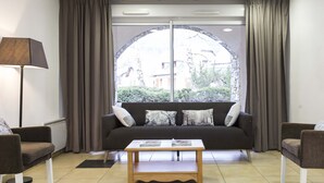 A living room with a sofa, two armchairs, a coffee table, and a floor lamp. - Résidence Odalys Soleil d'Aure (Saint-Lary-Soulan)
