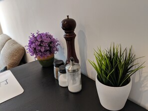 A table with a potted plant, salt and pepper shakers, and a decorative item. - Business Apartments Ratingen 5 (Ratingen)