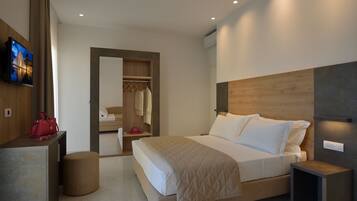 A modern hotel room with a large bed, bedside tables, a TV, and a wardrobe.