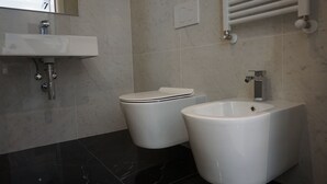 A modern bathroom with a sink, toilet, and bidet. - Hotel Ducale (Rimini)