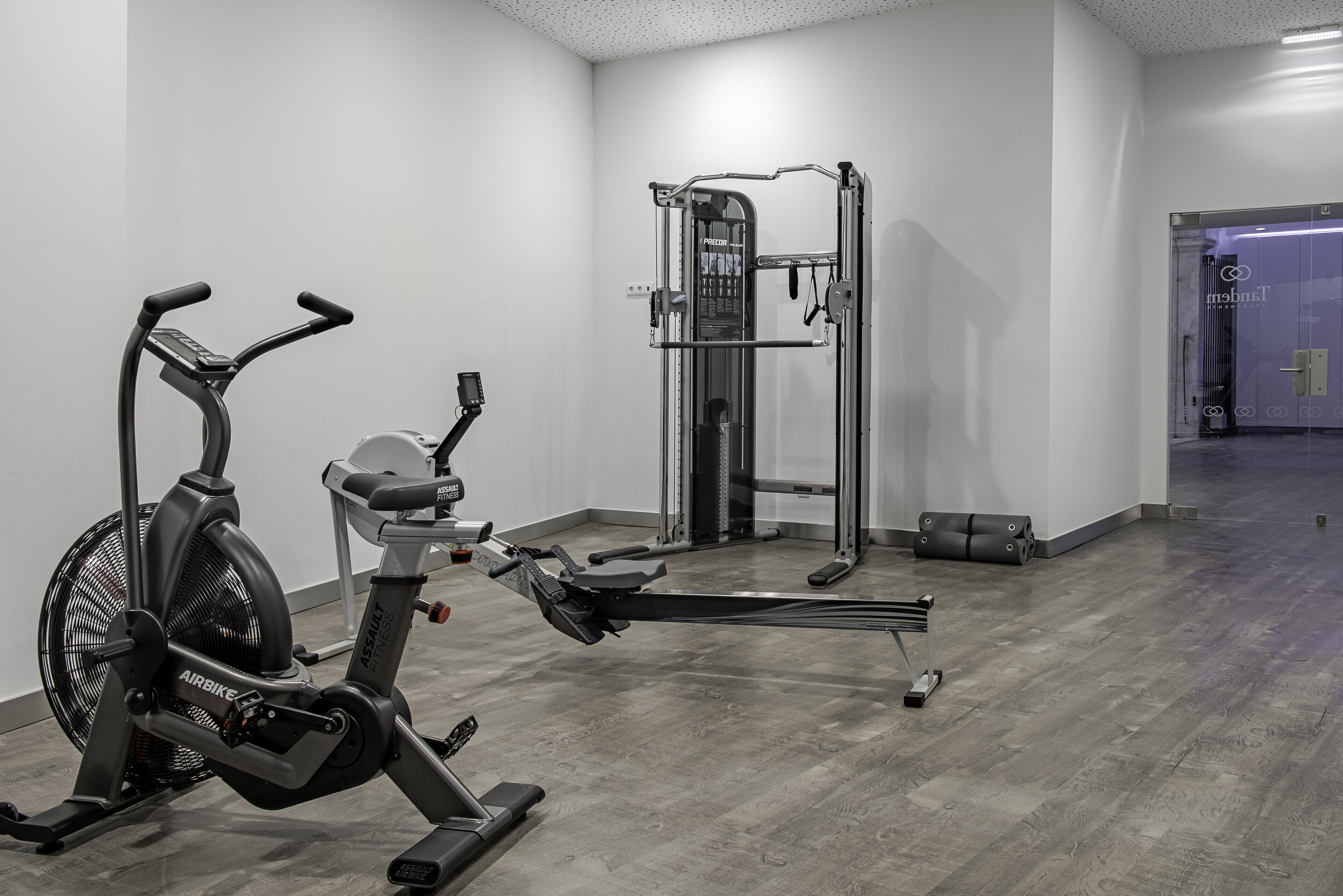 Una palestra con una cyclette, una sbarra per trazioni e una macchina per pesi.