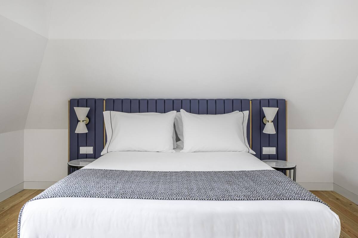 Un dormitorio moderno con una cama, dos mesitas de noche y una mesilla.