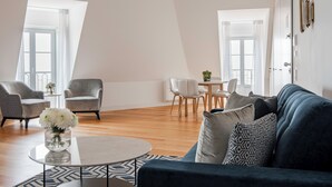 Una sala de estar moderna con un sofá, sillas, una mesa de centro y un comedor.
