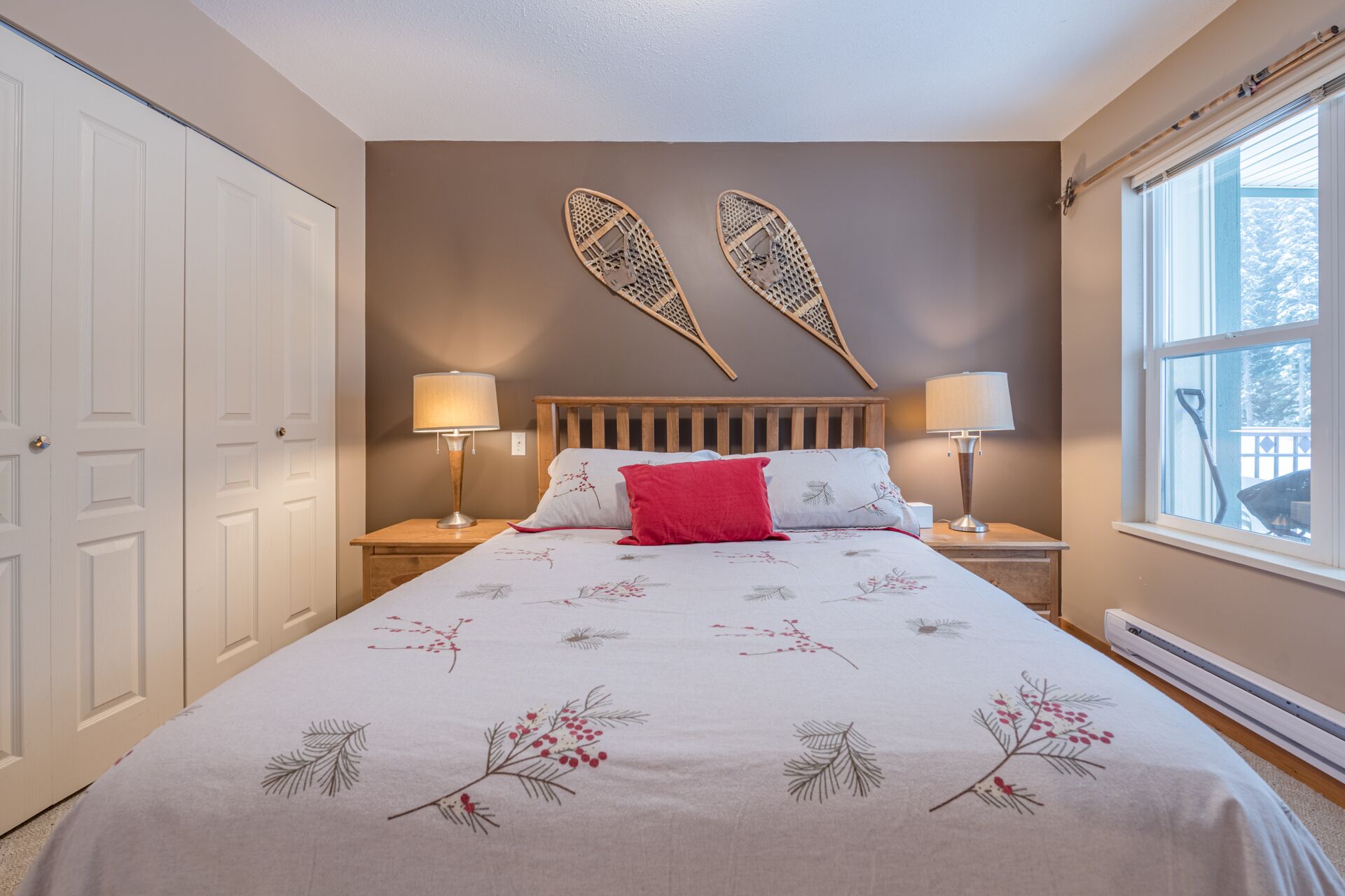 A bedroom with a bed, two nightstands, a window, and a door.