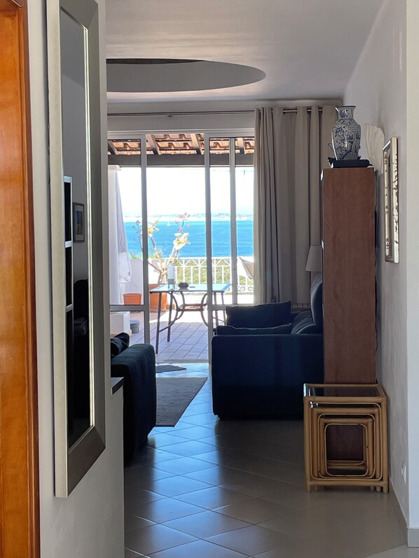 Una sala de estar moderna con vista al mar, un balcón y un comedor.