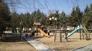 Ein Spielplatz mit verschiedenen Spielgeräten, darunter Rutschen und Klettergerüste.