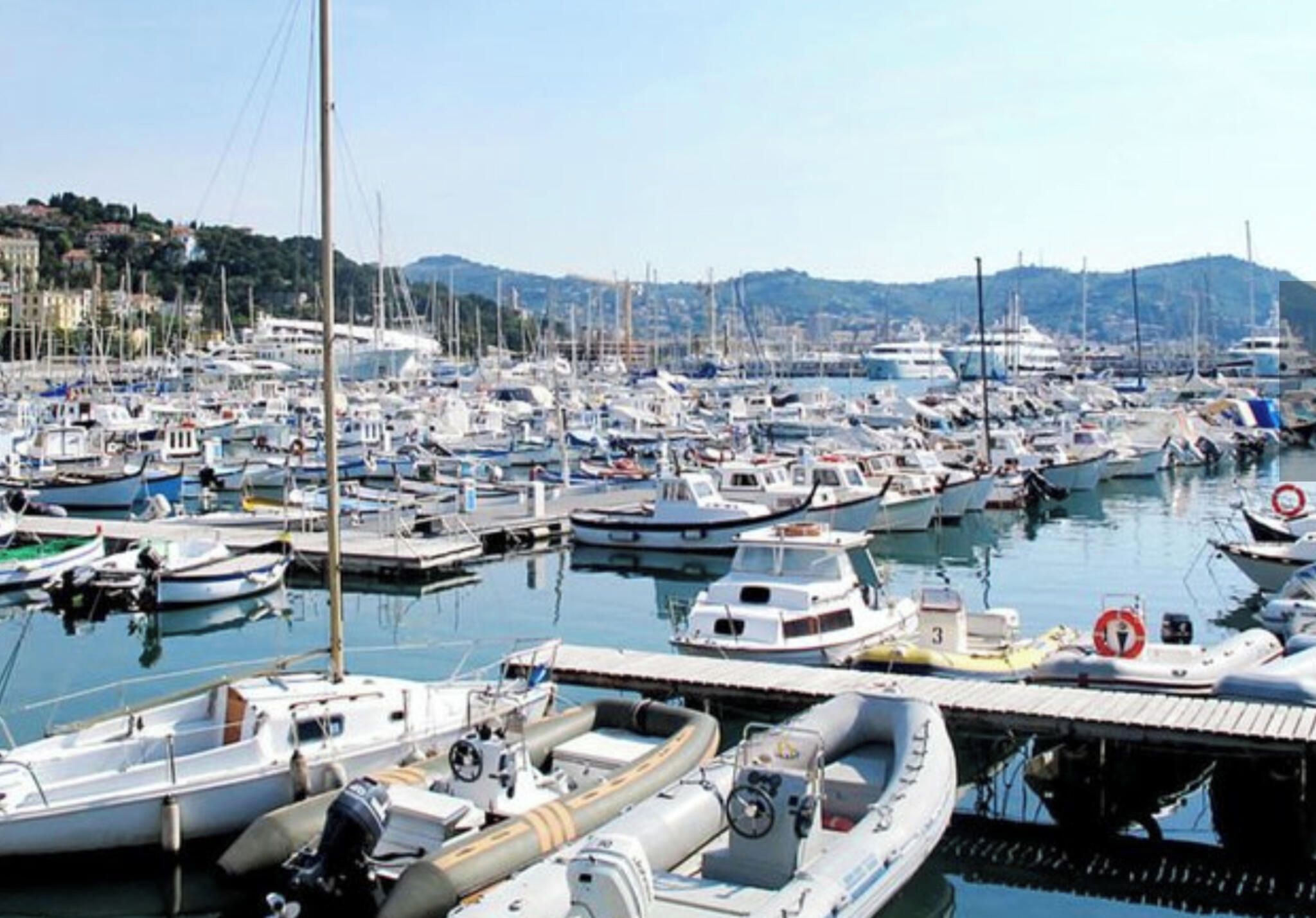 Un port de plaisance où sont amarrés différents types de bateaux, notamment des voiliers et des bateaux à moteur.