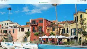 Una hilera de barcos estacionados a la orilla, con edificios coloridos al fondo.