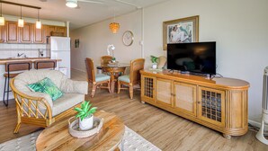 A living room with a sofa, chairs, a TV, and a wooden cabinet. - Gorgeous Oceanfront Condo with Spectacular Views! (Kihei)