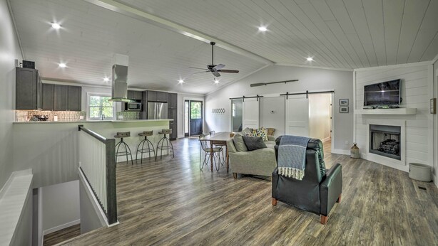 A spacious living area with a dining table, sofas, and a fireplace. - Lake Barkley Waterfront Home w/ Deck & Boat Dock! (Cadiz)