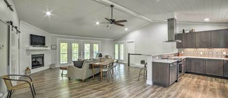A spacious living area with a fireplace, dining table, and comfortable seating.