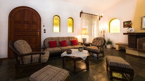 Una sala de estar acogedora con un sofá, sillas, una mesa de centro y una chimenea.