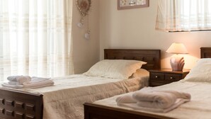 Una habitación de hotel con dos camas, una mesita de noche con lámpara y un adorno en la pared.