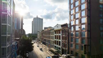 A city street lined with multi-story buildings, including a hotel with a sign that reads "a loft."