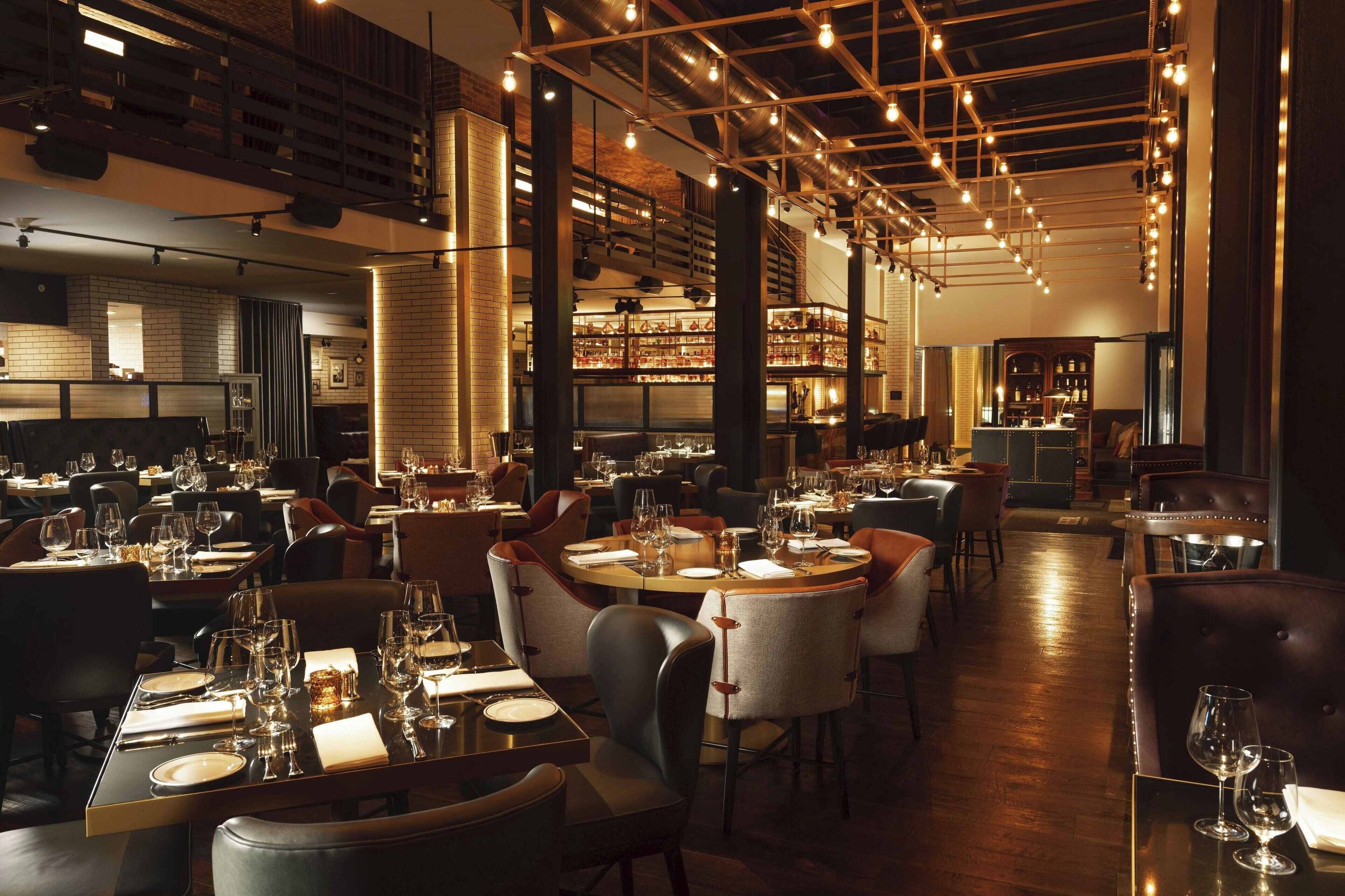 Un restaurant doté de plusieurs tables, de chaises et d’un bar.