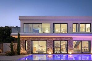 A modern two-story house with a swimming pool, large windows, and a stone facade. - Villa Ammos,  great view by the beach, next to the sea  (Ferma)