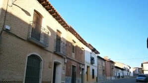 Une rangée de bâtiments traditionnels dotés de balcons et de fenêtres en arc de cercle, typiques d’une ville historique européenne.